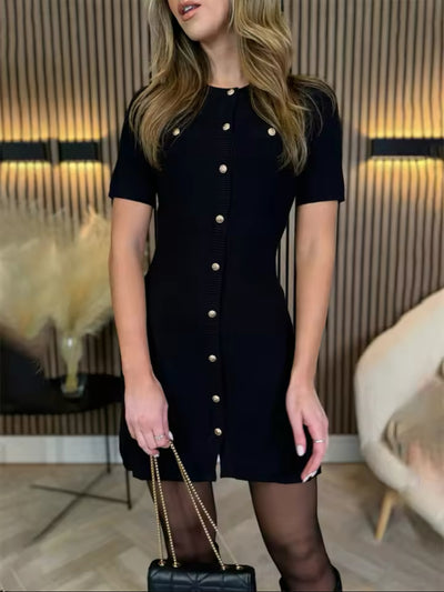 Robe courte en maille moulante, col rond et boutons dorés, avec poches décoratives pour un look moderne et raffiné.